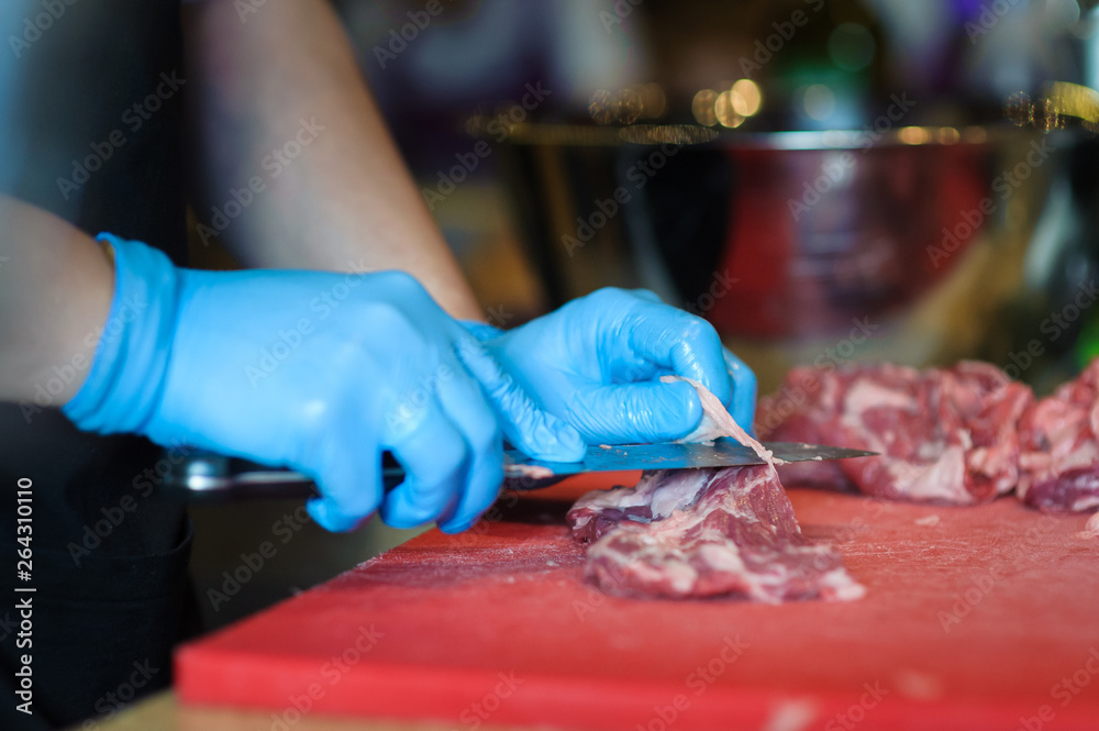 Obraz premium man's hands cutting meat