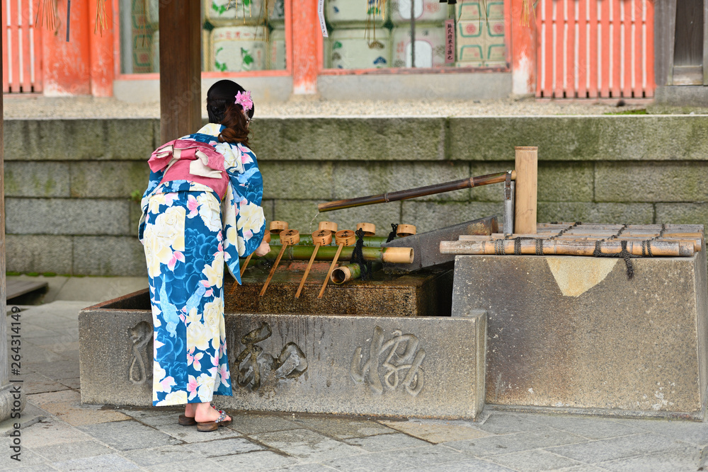 手水舎で手を浄める浴衣の女性