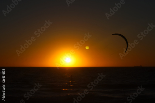 Kite surfing at sunset on Scarborough beach in Perth Western Australia. Clean sunset in the distance and the surfer about 50 meters away. © Sam Jeffs