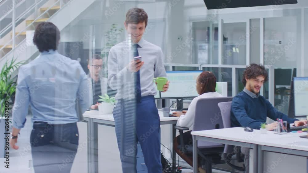 In the Bright Corporate Office Cool Businessman Wearing Tie and Shirt Rides Skateboard through Office Hallway. In the Background Professional People Working on Desktop Computers In the Bright Corporate Office Cool Businessman Wearing Tie and Shirt Rides Skateboard through Office Hallway. In the Background Professional People Working on Desktop Computers