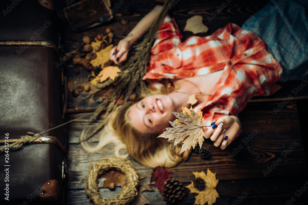 Girl in autumn in a seasonal clothes whith golden leaf. Beautiful sensual blonde. Autumn woman holding gold leaf. Attractive young woman in a seasonal clothes whith golden leaf. Autumn concept.