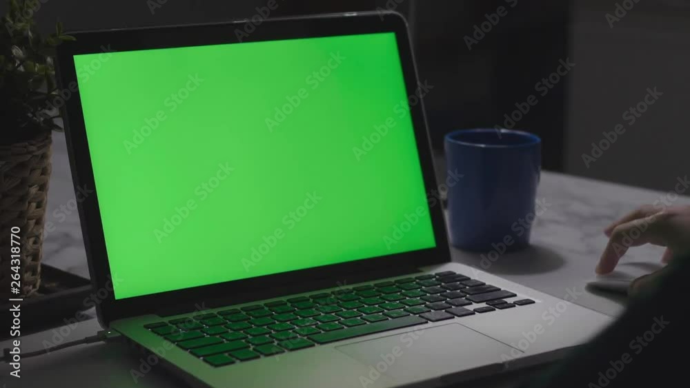 Over the shoulder shot of a young boy using on laptop computer on desk, looking at green screen. Dolly shot 60fps. Over the shoulder shot of a young boy using on laptop computer on desk, looking at green screen. Dolly shot 60fps.