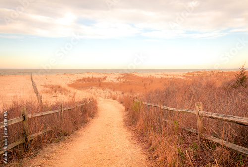 Sandy path leads to ocean in Cape May, NJ, at sunrise