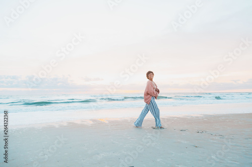 Happy Young Woman on Beach During Sunrise