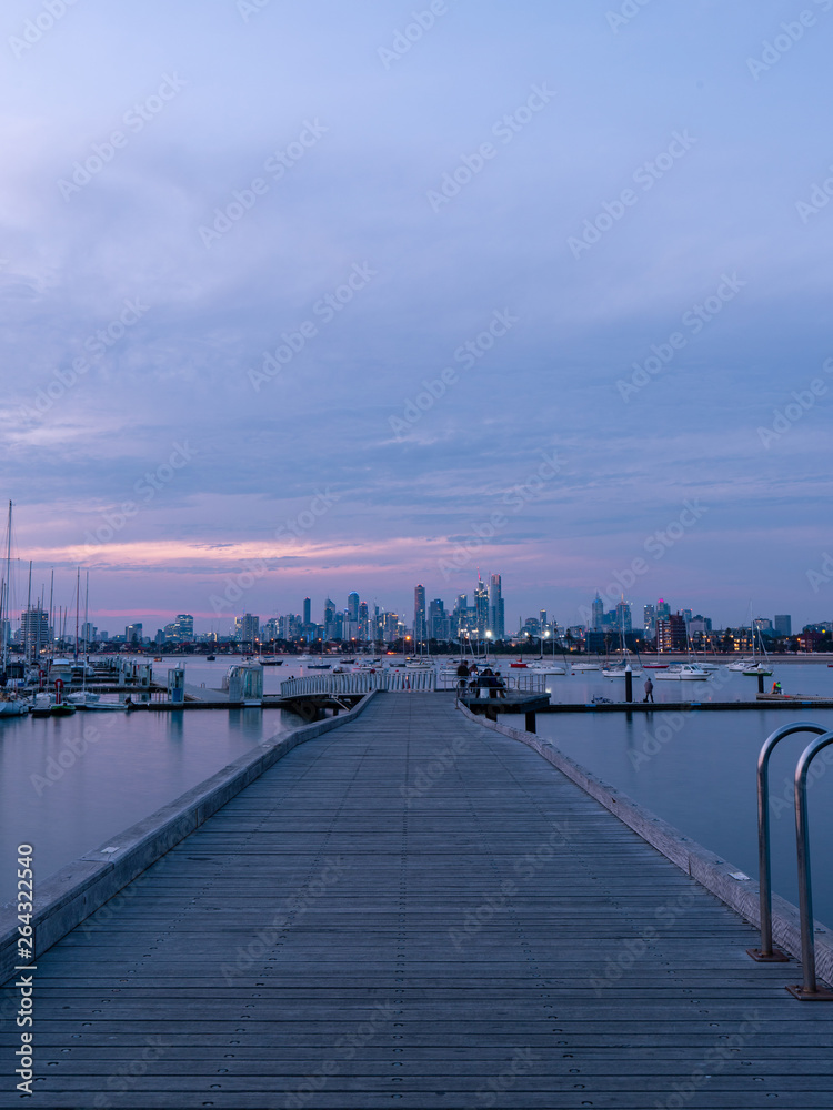Melbourne skyline, pier, and boats view at dusk time.