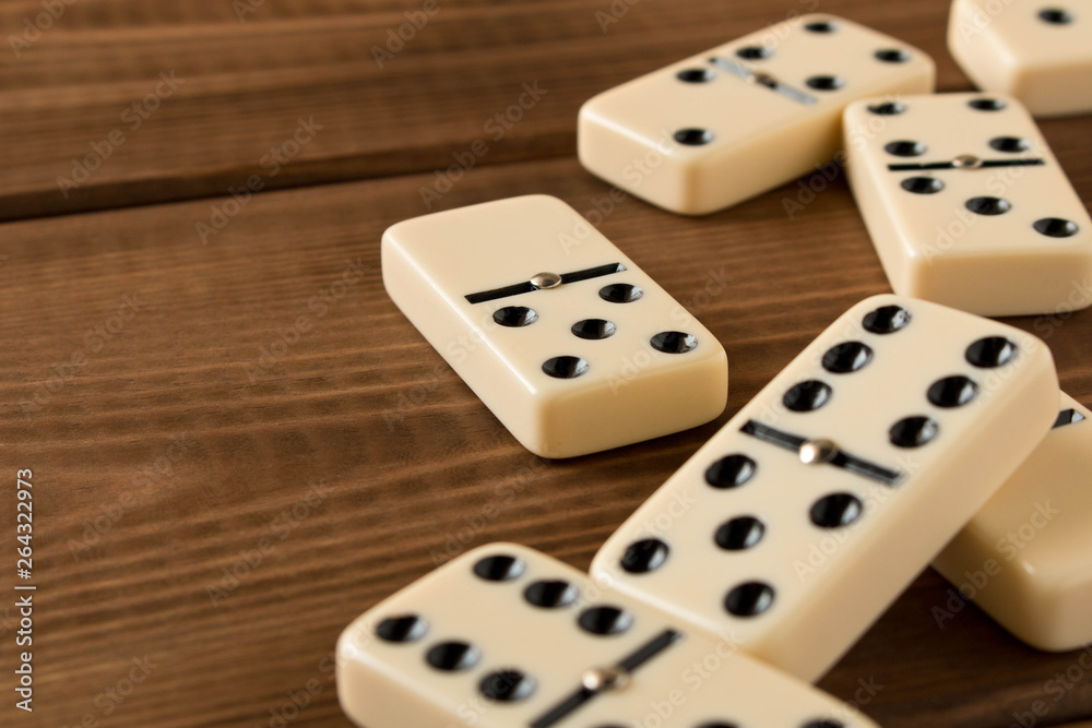 Playing dominoes on a wooden table. Domino effect. Playing dominoes on a wooden table. Domino effect.