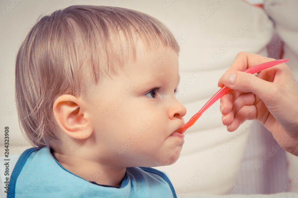 Hungry little baby boy eating snack in preschool or nursery, dessert for kids concept Hungry little baby boy eating snack in preschool or nursery, dessert for kids concept