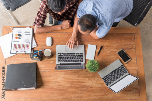 Two man working on their computers. the view from the top. two laptops, two persons.