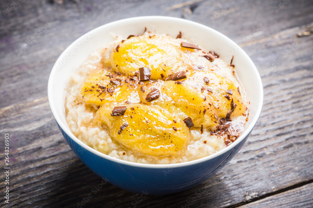 Oatmeal with roasted bananas and chocolate. Selective focus. Shallow depth of field. Oatmeal with roasted bananas and chocolate. Selective focus. Shallow depth of field.