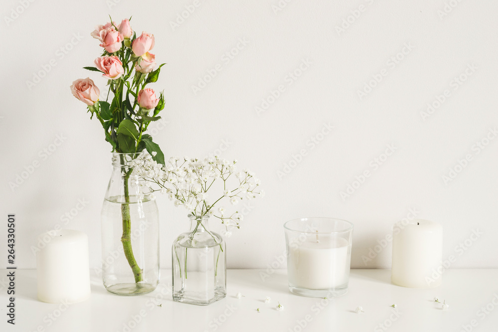 White arrangement of roses, baby's breath flowers and candles. Copy space for lettering White arrangement of roses, baby's breath flowers and candles. Copy space for lettering