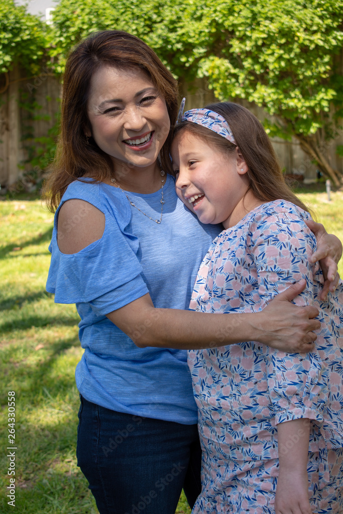 Latina Mother and Daughter Smiling and laughing outside in back yard Latina Mother and Daughter Smiling and laughing outside in back yard