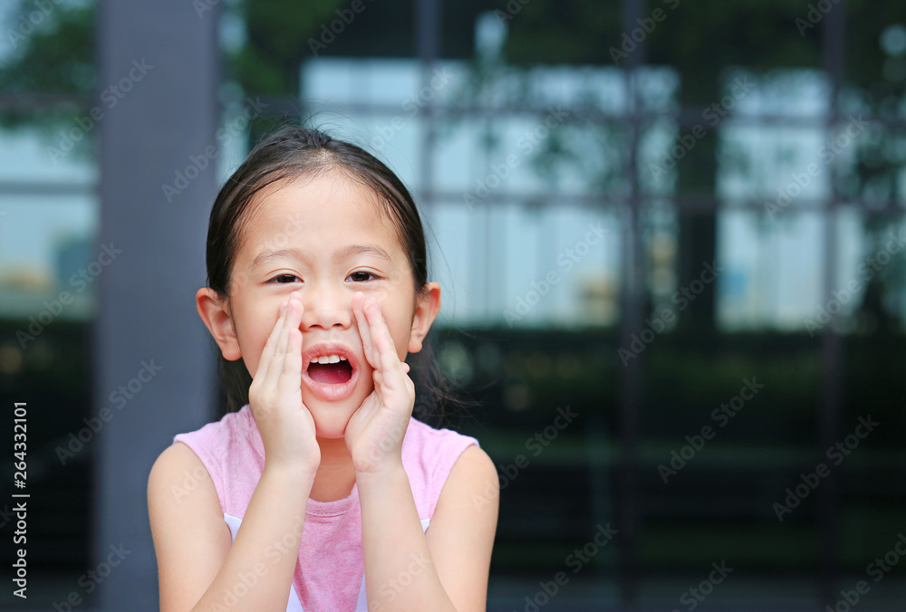 Portrait little Asian child girl acting and shouting through hands like megaphone. Communication concept. Portrait little Asian child girl acting and shouting through hands like megaphone. Communication concept.
