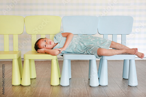 Photos Portrait child preschool girl in a Kindergarten room lying on plastic baby chair