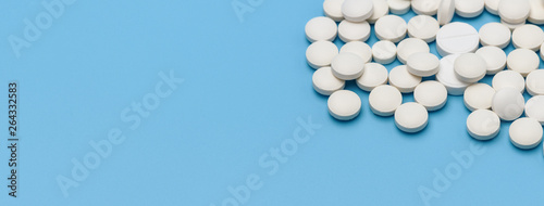 Banner. A lot of white round tablets on the right on a blue background, on the left an empty space for an advertising signature