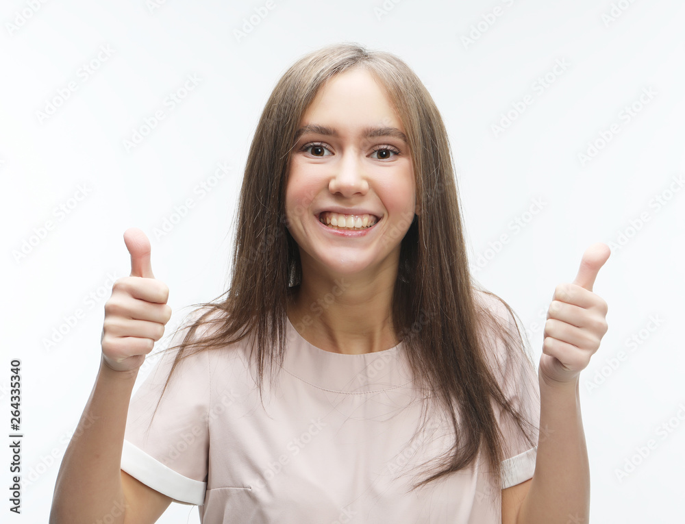 Happy young caucasian female making thumb up sign and smiling cheerfully, showing her support and respect to someone. Happy young caucasian female making thumb up sign and smiling cheerfully, showing her support and respect to someone.