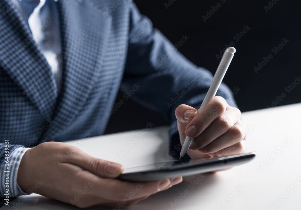Man in business suit sitting at desk with tablet Man in business suit sitting at desk with tablet