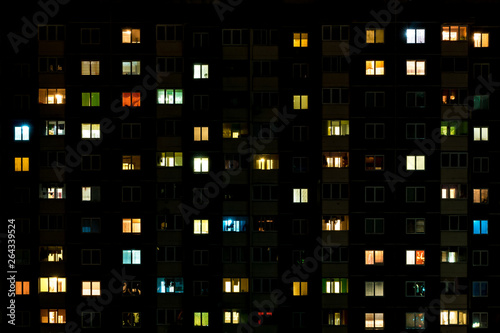 Night time lapse of Light in the windows of a multistory building. life in a big city