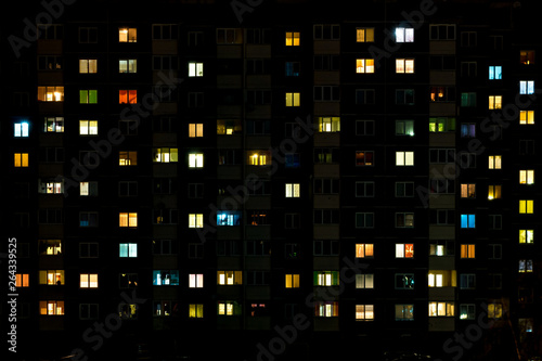 Canvas Print Night time lapse of Light in the windows of a multistory building