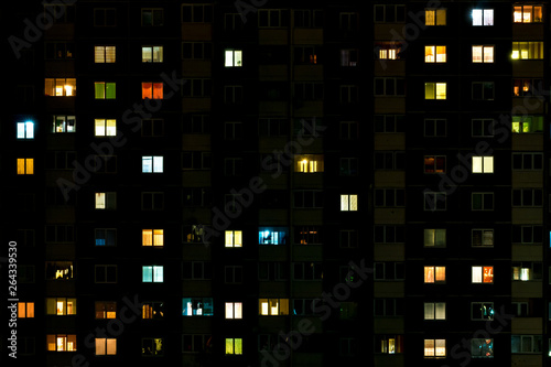Night time lapse of Light in the windows of a multistory building. life in a big city