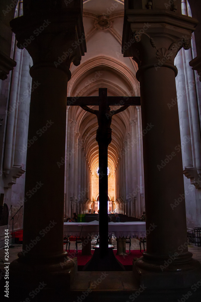 Alcobaca, Portugal. Crucifix with Jesus Christ nailed to cross in altar of Monastery of Santa Maria de Alcobaca Abbey. Medieval Gothic architecture. Cistercian Religious Order