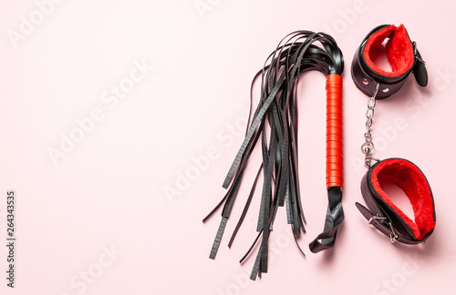 Set of erotic toys for BDSM. The game of sexual slavery with handcuffs, whip, gag and leather straps. Intimate games. Copy space for text.