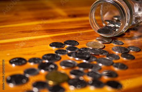 Assorted Coins Spilling From A Jar