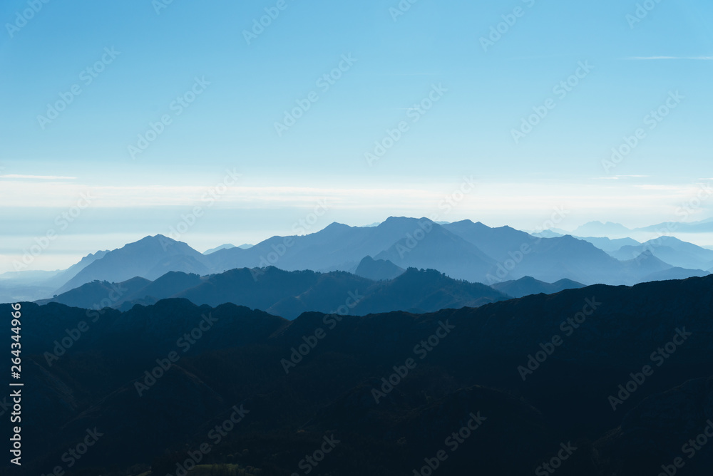 Fototapeta premium Scenic view of silhouettes of mountains in the morning mist