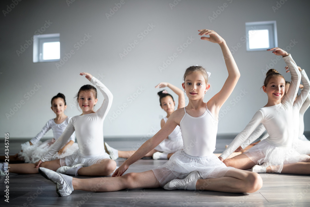 Group of fit happy children exercising ballet in studio together Group of fit happy children exercising ballet in studio together