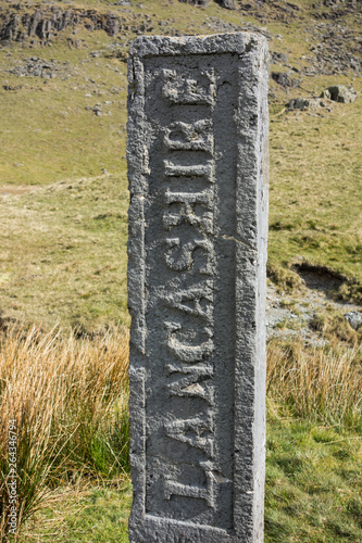 The Lancashire side of the Three Shires stone , a historic boundary stone / marker at the top of Wrynose Pass in the English Lake District photo