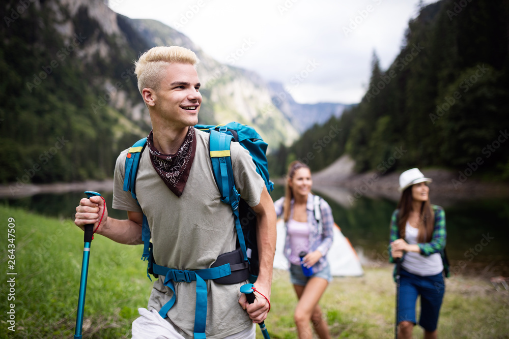 Group of happy young people friends hiking together outdoor - obrazy, fototapety, plakaty 