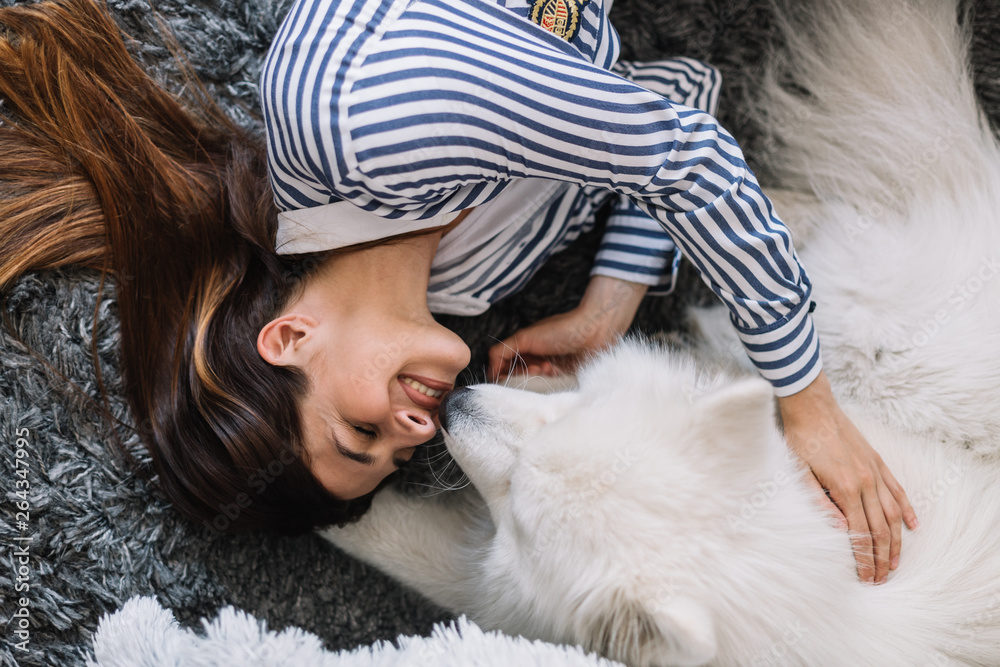 Cute girl petting her dog. Beautiful girl having fun with her dog and enjoying herself. Girl and her dog at home Cute girl petting her dog. Beautiful girl having fun with her dog and enjoying herself. Girl and her dog at home