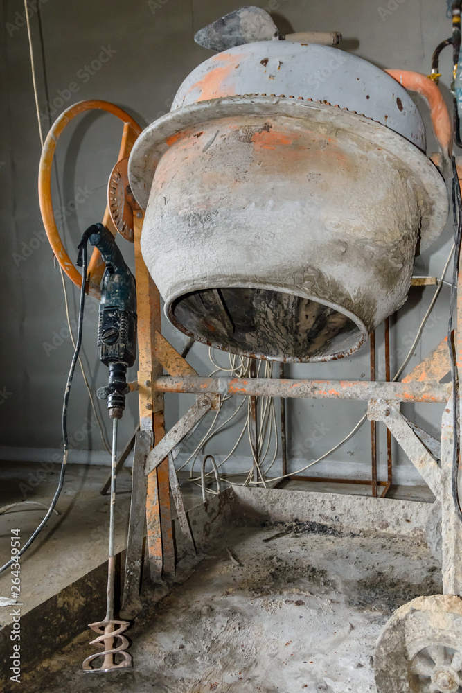 Concrete mixer and hammer drill at the construction site Concrete mixer and hammer drill at the construction site