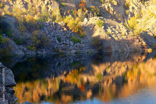 Radon Lake in former abandoned granite quarry full with pure transparent water at sunset. Ukraine, Migeia.