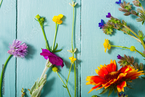 herbal and wildflowers on blue wooden table background