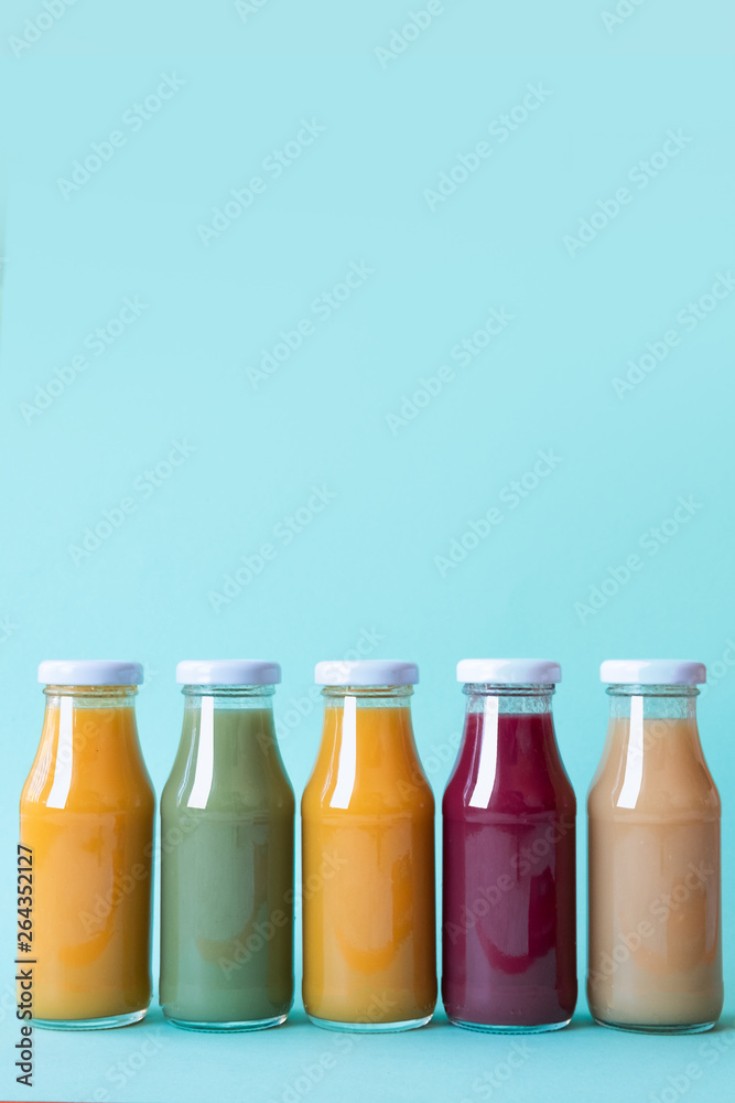 Vegetable and fruit juice bottles isolated on blue background. Copy space Vegetable and fruit juice bottles isolated on blue background. Copy space