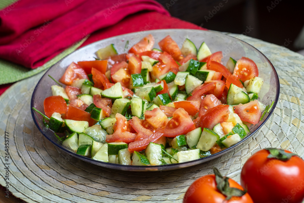 Delicious natural salad of fresh vegetables tomatoes and cucumbers with herbs, healthy food, cooking, close-up