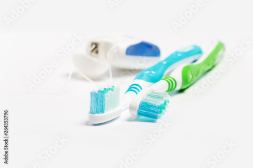 Dental floss and toothbrush isolated on a white background.