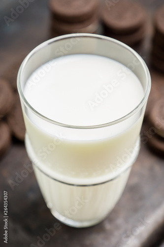 Glass of cold milk and chocolate cookies on the rustic background. Selective focus. Shallow depth of field. 