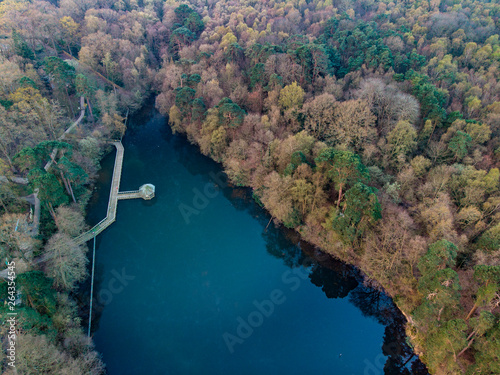 Stunning drone aerial landscape image of a lake in the Englsh countryside with blue sky reflected in lake at sunrise photo