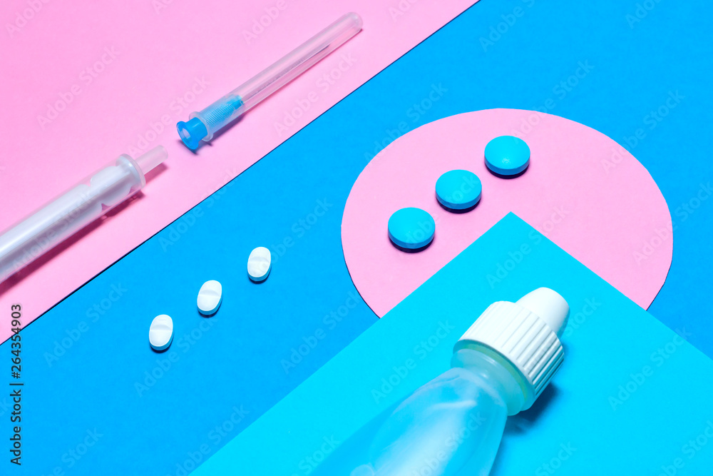 Medical stuff and pills minimalistic flat lay with copy space on a paper background of blue and pink. Medical stuff and pills minimalistic flat lay with copy space on a paper background of blue and pink.