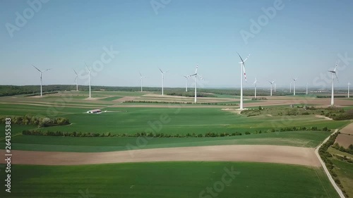 Windmills on agricultural area at countryside - Scenic drone shot at daytime of renewable energy photo