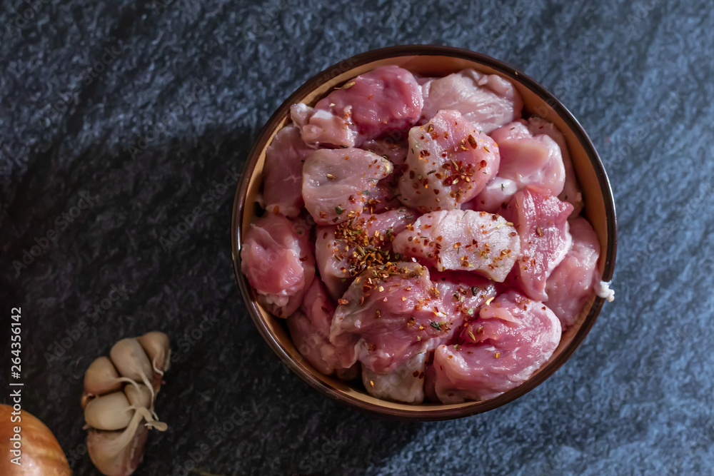 Ingredients for making pilaf, meat, onion and garlic on a dark background. Horizontal orientation