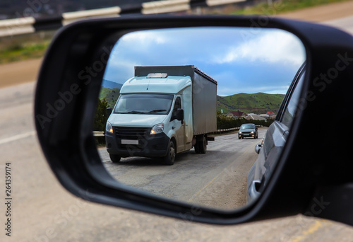View through the rearview mirror of the car on the movement of cars