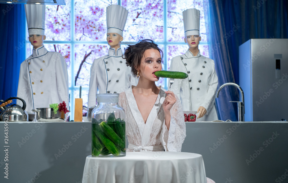 Girl in a restaurant eating cucumbers from banks Girl in a restaurant eating cucumbers from banks