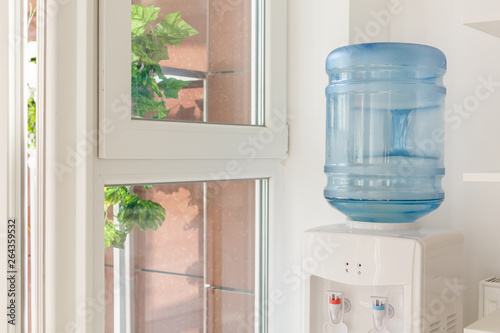 Fotografija blue water gallon on electric water cooler in office area