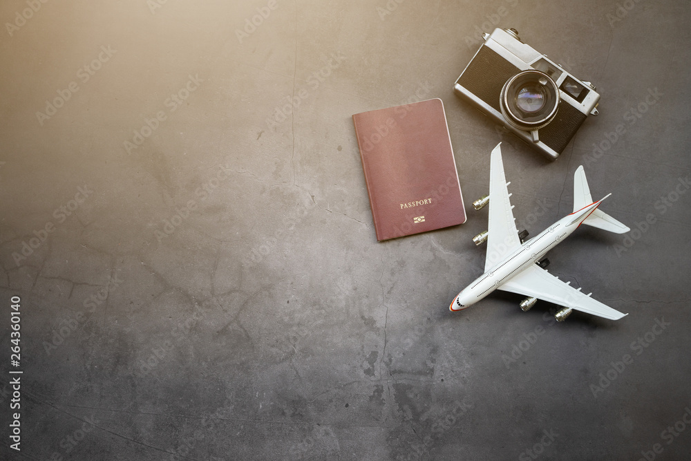 Flat lay design of travel concept with camera, passport, plane, on black background.
