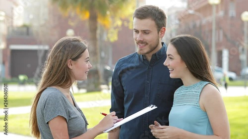 Happy couple asking a survey in the street