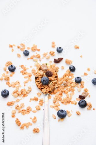 Crispy muesli and blueberry on a spoon Breakfast cereal isolated on white background, selective focus, top view