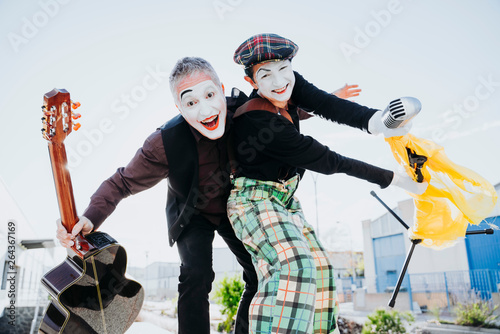 Two mimes on the street singing and playing guitar photo