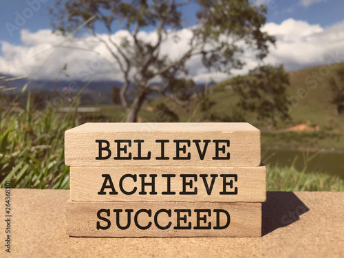 Motivational and inspirational words - Believe, Achieve, Succeed written on rectangular wood blocks. © Coompia77